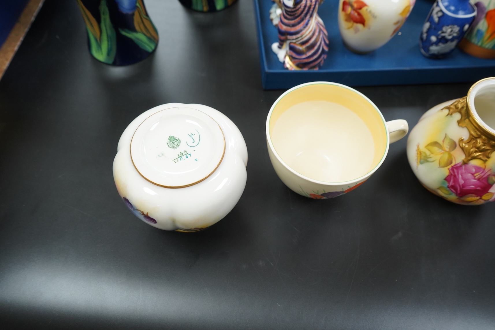 A collection of mixed porcelain and pottery to include four Worcester vases, one signed H. Blake, Clarice Cliff crocus pattern cup, saucer and sugar bowl and two Doulton Imari paperweights, largest 13cm high